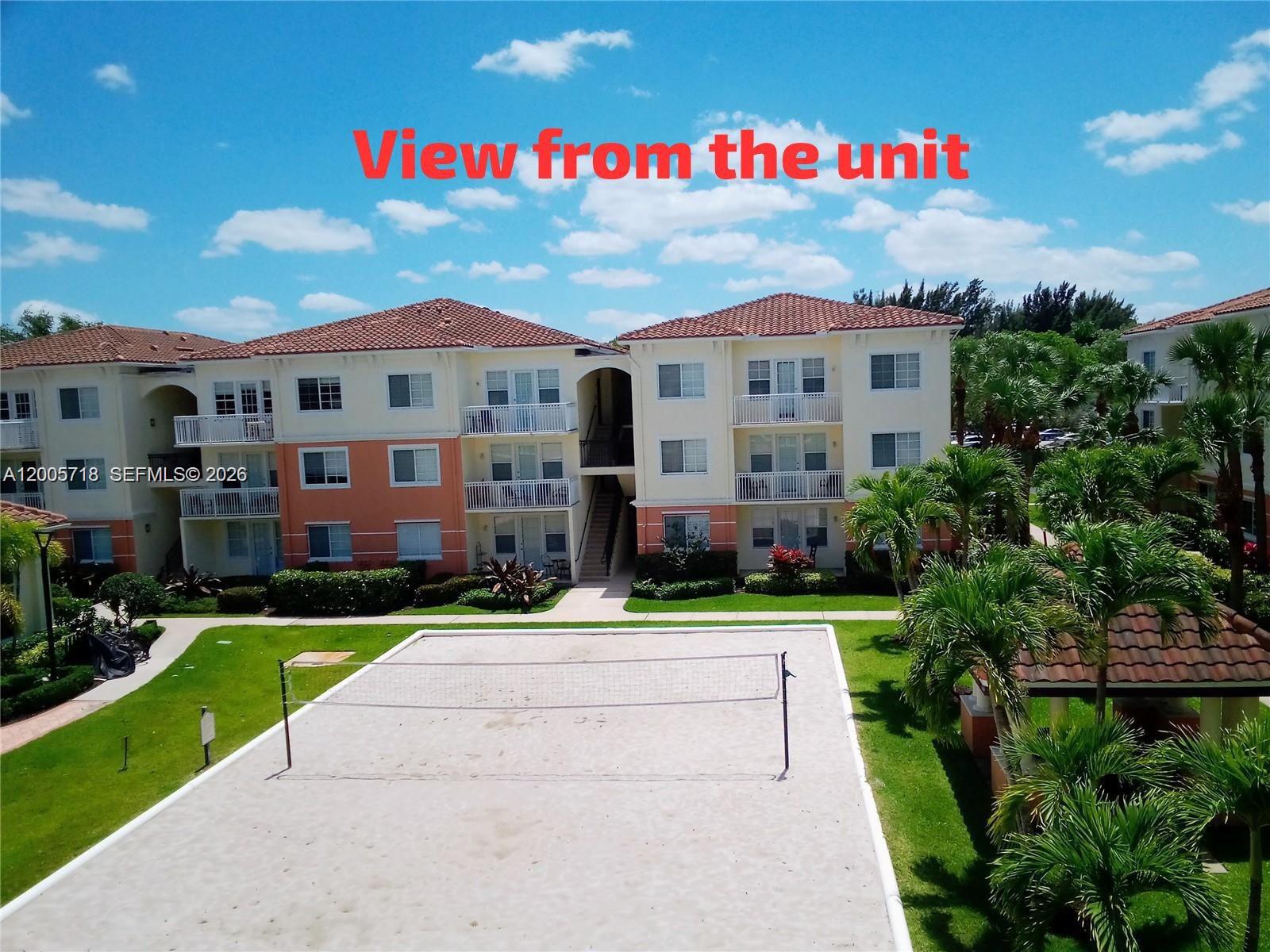 An outdoor sand volleyball court sits in front of a multi-story apartment building — 9845 Baywinds Dr # 6308, West Palm Beach FL 33411, WEST PALM BEACH, FL
