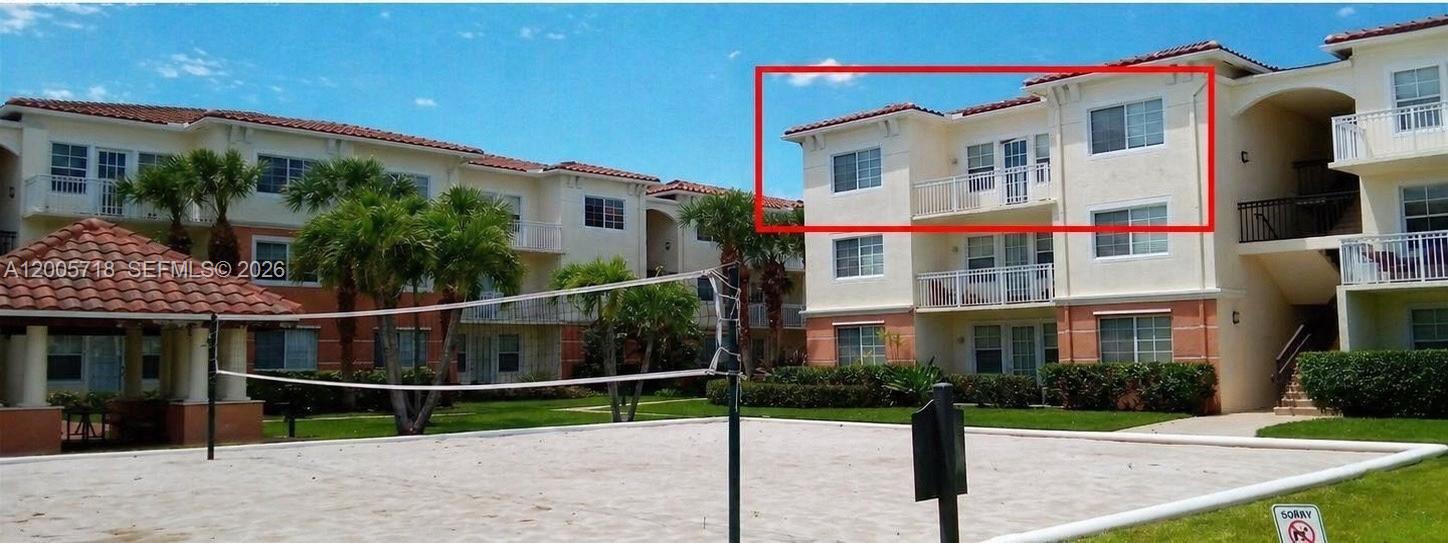 A three-story apartment building with a red tile roof overlooks a sand volleyball court — 9845 Baywinds Dr # 6308, West Palm Beach FL 33411, WEST PALM BEACH, FL