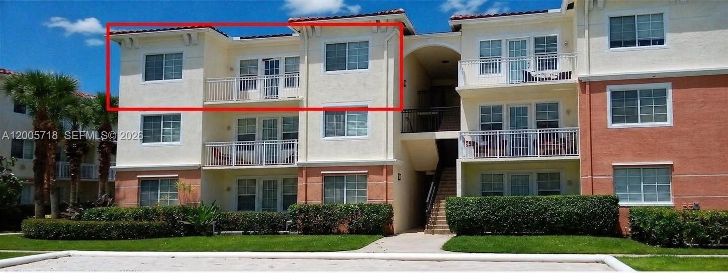 An exterior view of a three-story apartment building with a red-outlined top-floor unit — 9845 Baywinds Dr # 6308, West Palm Beach FL 33411, WEST PALM BEACH, FL