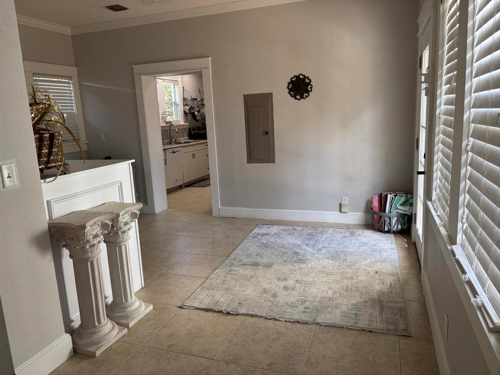 A room with tile flooring, a rug, a breaker panel, and a doorway to a kitchen — 808 Kanuga Drive, West Palm Beach FL 33401, WEST PALM BEACH, FL