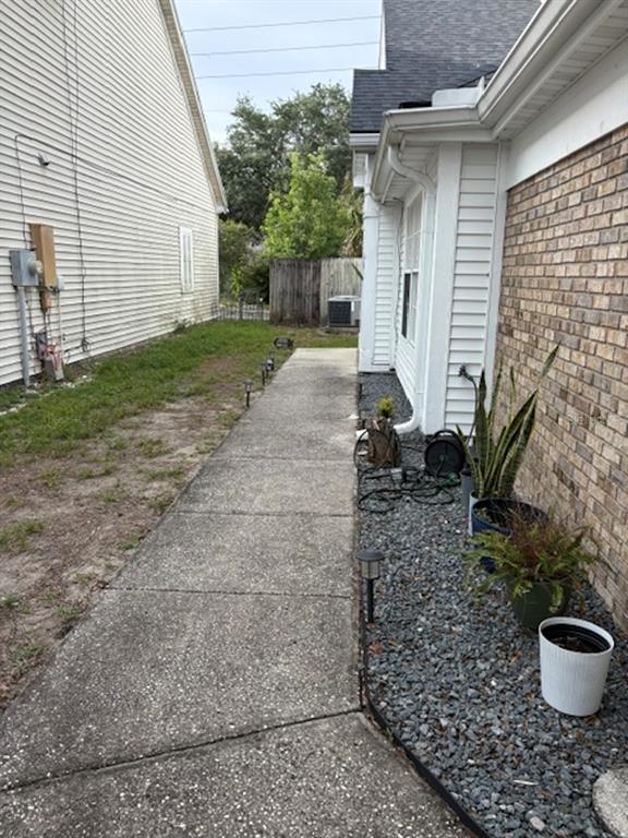 A concrete walkway runs between a vinyl-sided house and a brick-sided house with gravel landscaping — 1948 CRANBERRY ISLES WAY, APOPKA, FL