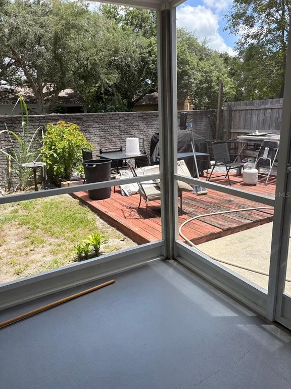 A view from a screened-in porch looking out onto a wooden deck and backyard — 1948 CRANBERRY ISLES WAY, APOPKA, FL