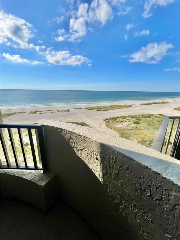 A balcony view overlooking a sandy beach and the ocean under a blue sky — 1290 GULF BOULEVARD UNIT 1003, CLEARWATER BEACH, FL