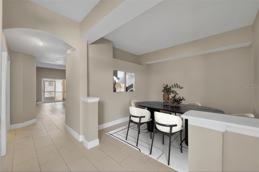 A dining area with a dark oval table and chairs sits on a patterned rug — 676 SANDY NECK LANE UNIT 102, ALTAMONTE SPRINGS, FL