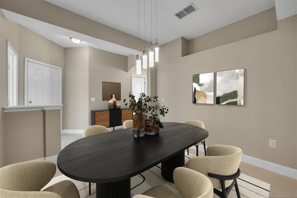 A dining room features a black oval table, beige chairs, and modern pendant lighting — 676 SANDY NECK LANE UNIT 102, ALTAMONTE SPRINGS, FL