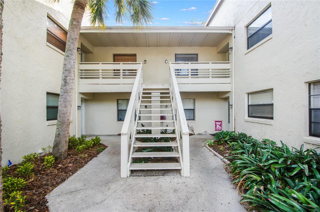 An exterior view of a two-story apartment building with a central wooden staircase — 439 S NETHERWOOD CRESCENT UNIT 439, ALTAMONTE SPRINGS, FL