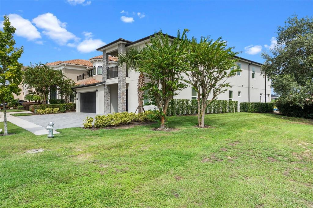 A two-story house with a stone-accented entrance, a paved driveway, and a grassy front yard — 7864 PALMILLA COURT, REUNION, FL