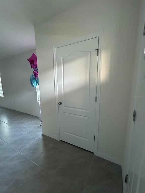 A white interior door stands in a hallway with tiled flooring and light-colored walls — 2000 RANKIN STREET, KISSIMMEE, FL