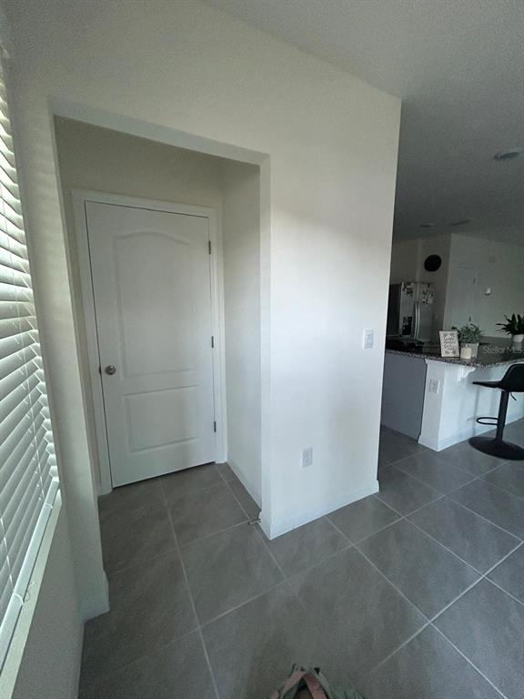 A white interior door sits next to a kitchen counter with bar stools — 2000 RANKIN STREET, KISSIMMEE, FL