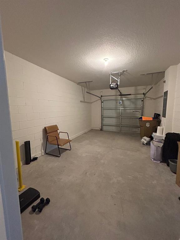 A garage with a concrete floor, white block walls, a single chair, and gym equipment — 2000 RANKIN STREET, KISSIMMEE, FL