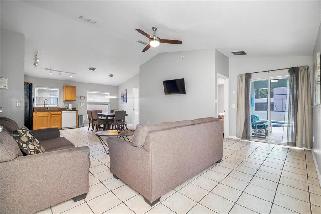 A living room with tile floors, a ceiling fan, and an open view of the kitchen — 126 SUNDOWN COURT, DAVENPORT, FL