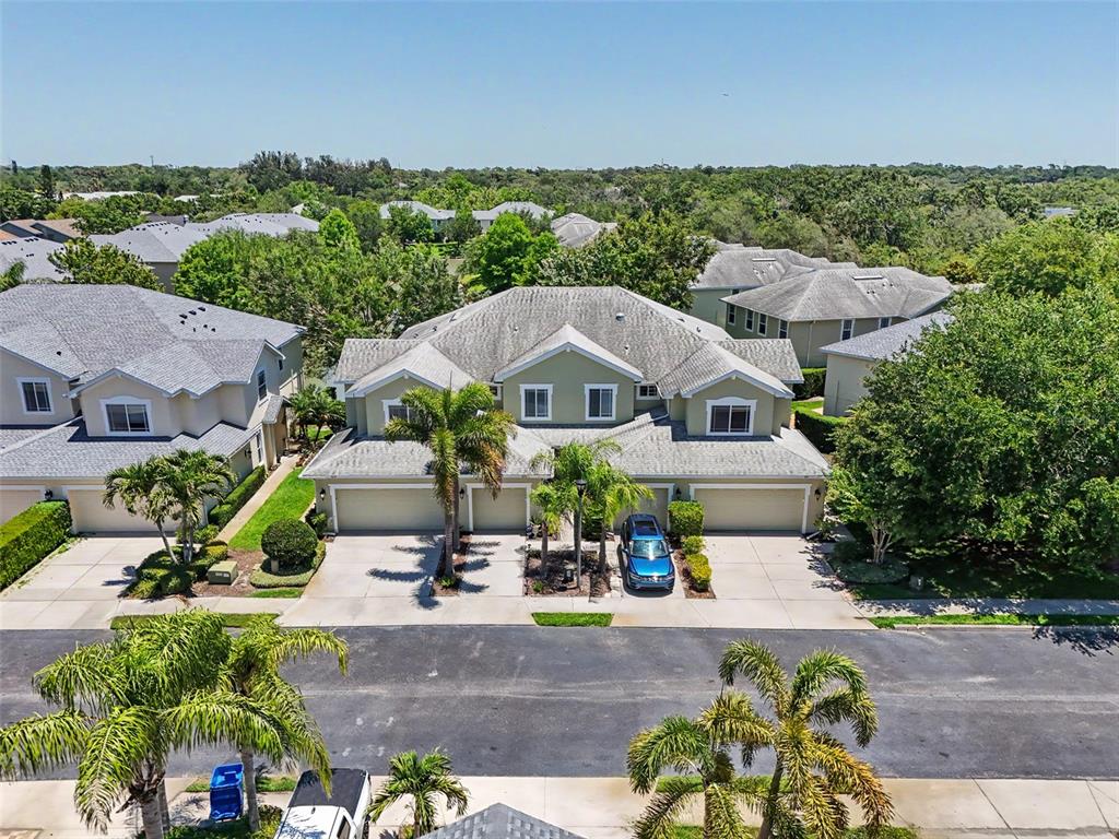 An aerial view shows a two-story townhouse with a gray roof and attached garages — 441 HARBOR RIDGE DRIVE, PALM HARBOR, FL