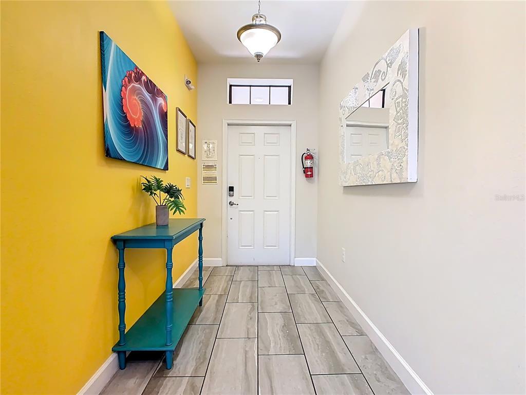 An entryway features a yellow accent wall, a teal console table, and tile flooring — 5528 SOLTERRA CIRCLE, DAVENPORT, FL