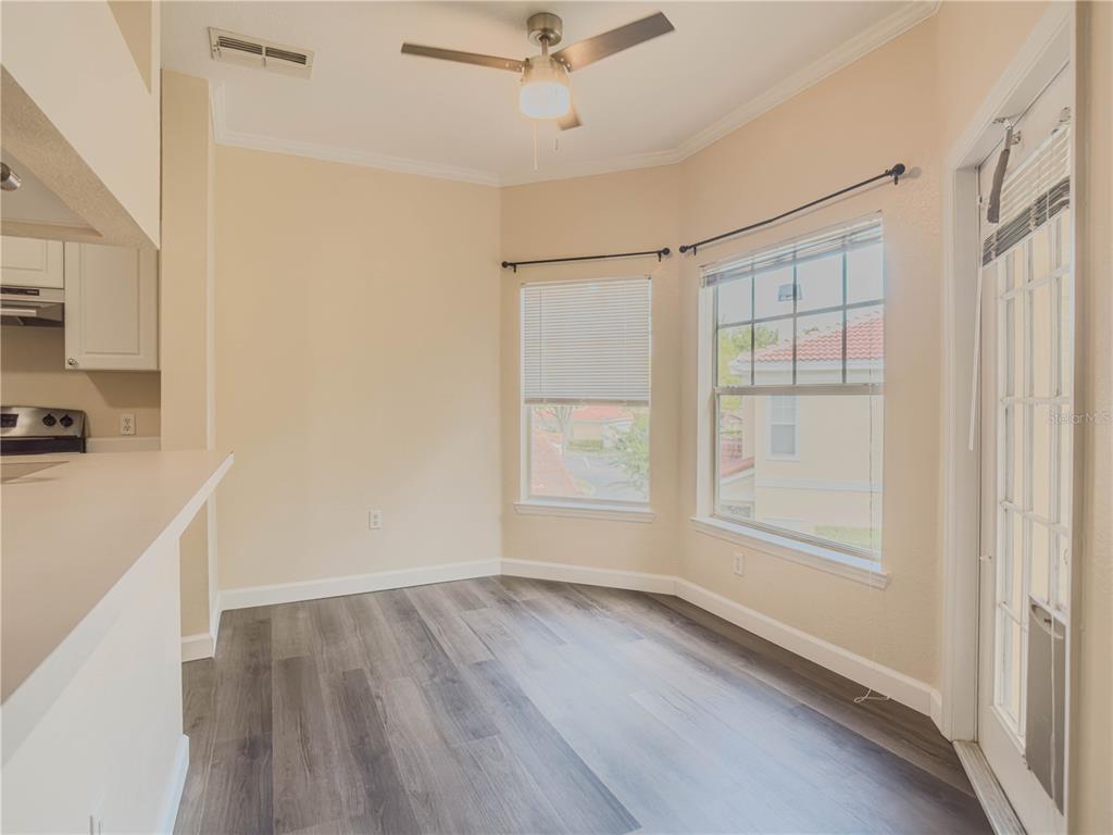 A dining area with wood-look flooring, a ceiling fan, and windows overlooking a neighborhood — 2226 ARBOR LAKES CIRCLE, SANFORD, FL