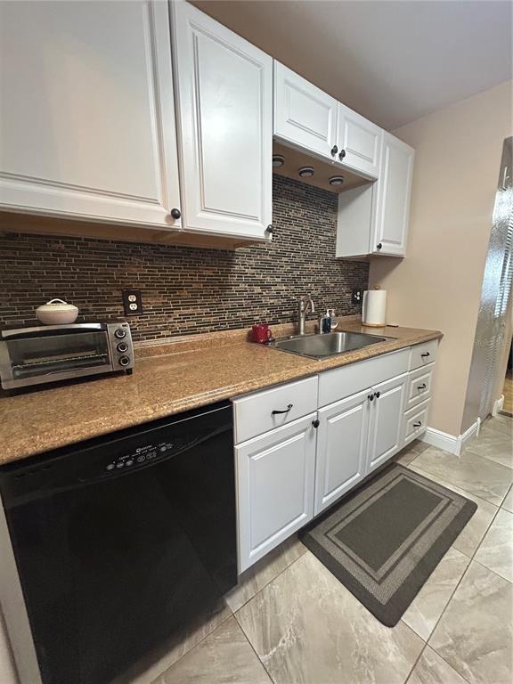 A kitchen features white cabinets, a brown speckled countertop, and a dark tiled backsplash — 10037 62ND TERRACE N UNIT 15, ST PETERSBURG, FL