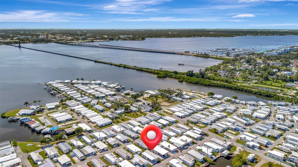 An aerial view shows a mobile home community located along a waterfront with a bridge — 247 PALM LANE, PALMETTO, FL