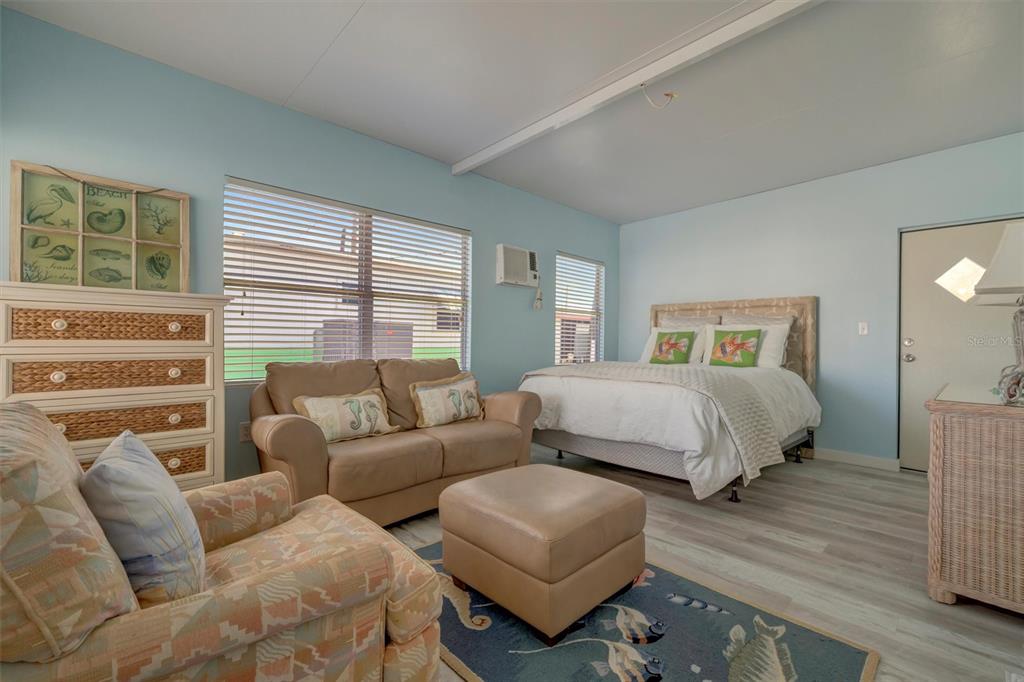 A bedroom with light blue walls, a bed, a sofa, and a patterned area rug — 247 PALM LANE, PALMETTO, FL