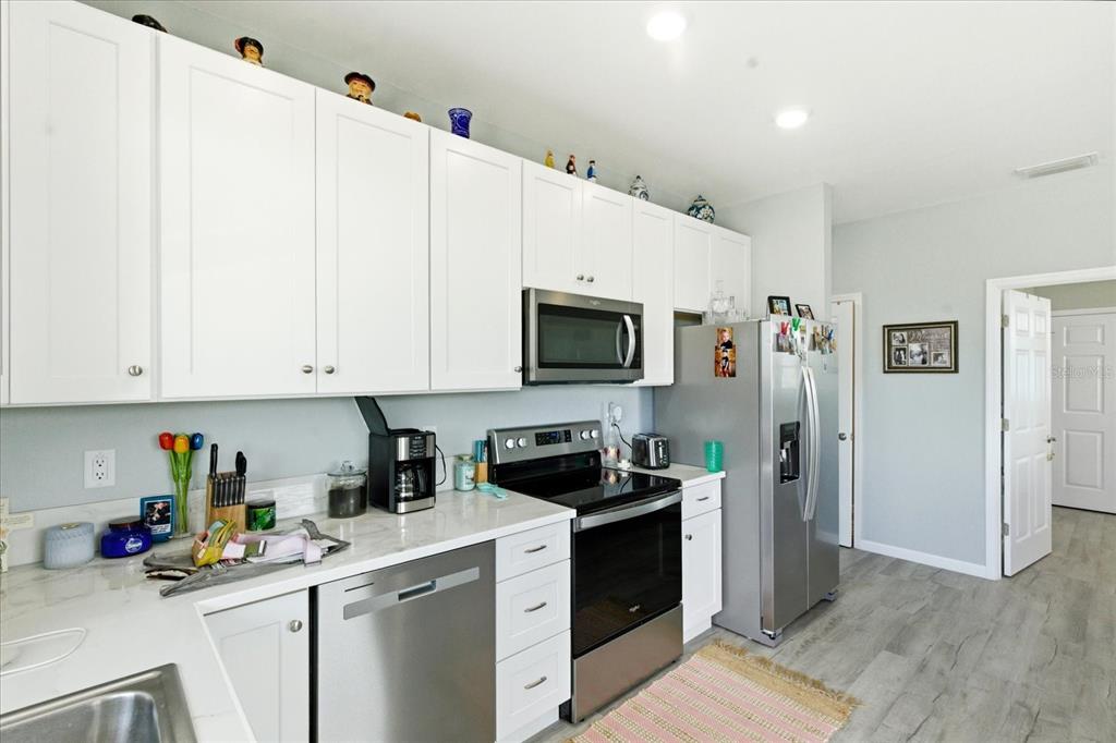A kitchen with white cabinets, stainless steel appliances, and light-colored countertops — 3605 EAGLE NEST DRIVE, HERNANDO BEACH, FL