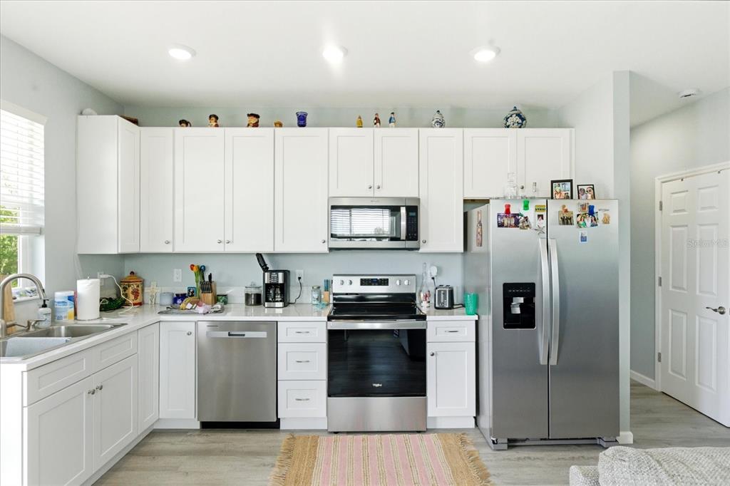 A kitchen features white cabinets, stainless steel appliances, and light-colored flooring — 3605 EAGLE NEST DRIVE, HERNANDO BEACH, FL