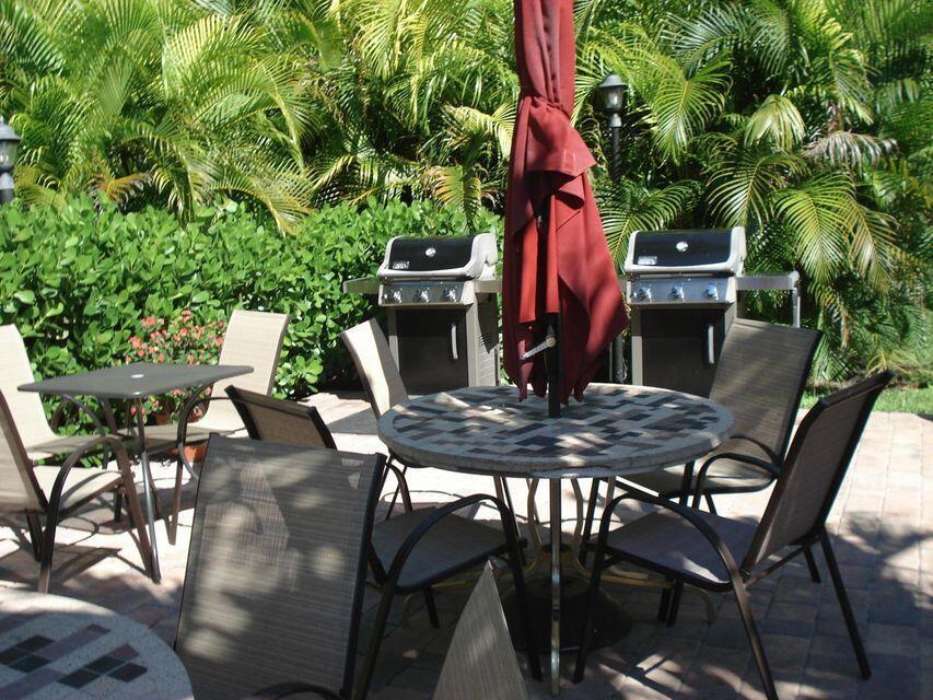 A patio area features a round tiled table, chairs, and two stainless steel gas grills — 950 Ponce De Leon Road # 5010, Boca Raton FL 33432, BOCA RATON, FL