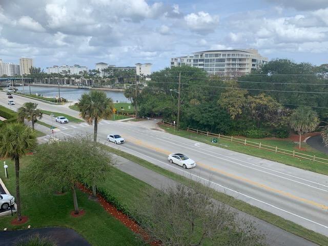 An elevated view of a multi-lane road, palm trees, a waterway, and nearby apartment buildings — 950 Ponce De Leon Road # 5010, Boca Raton FL 33432, BOCA RATON, FL