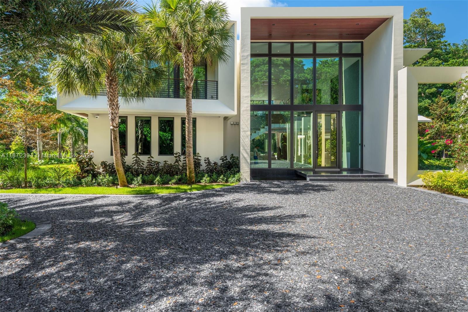 A modern two-story house with a glass facade and a gravel driveway — 9440 Old Cutler Ln, Coral Gables FL 33156, CORAL GABLES, FL