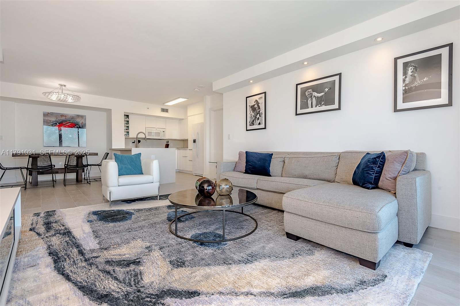 A living room features a grey sectional sofa, a round coffee table, and a patterned rug — 90 Alton Rd # 2410, Miami Beach FL 33139, MIAMI BEACH, FL