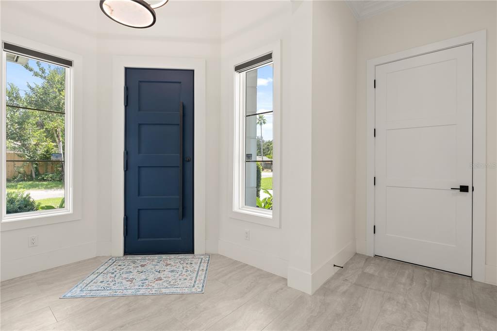 A bright entryway features a blue front door, two side windows, and a white door — 3125 S BUMBY AVENUE, ORLANDO, FL