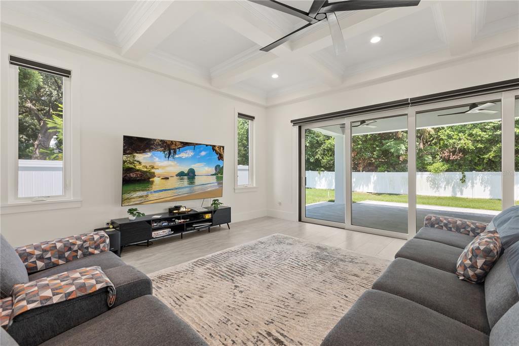 A living room features a coffered ceiling, large sliding glass doors, and a television console — 3125 S BUMBY AVENUE, ORLANDO, FL
