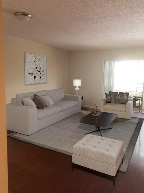 A living room features a light-colored sofa, an armchair, a coffee table, and an ottoman — 13612 SOUTH VILLAGE DRIVE UNIT 5-207, TAMPA, FL