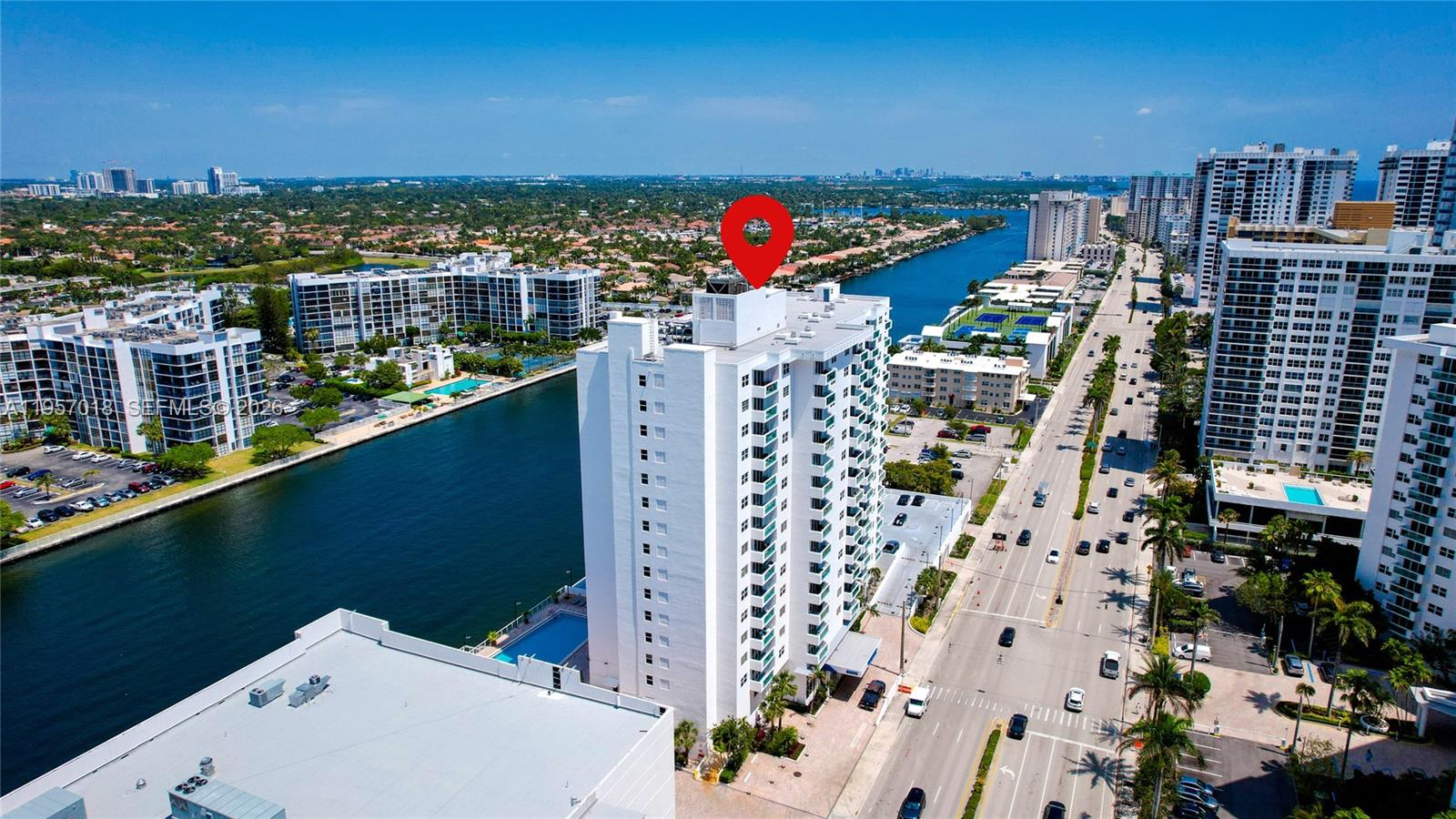 A view of the ocean and neighboring buildings from a balcony through sliding glass doors — 3000 S OCEAN DR # 1006, Hollywood FL 33019, HOLLYWOOD, FL