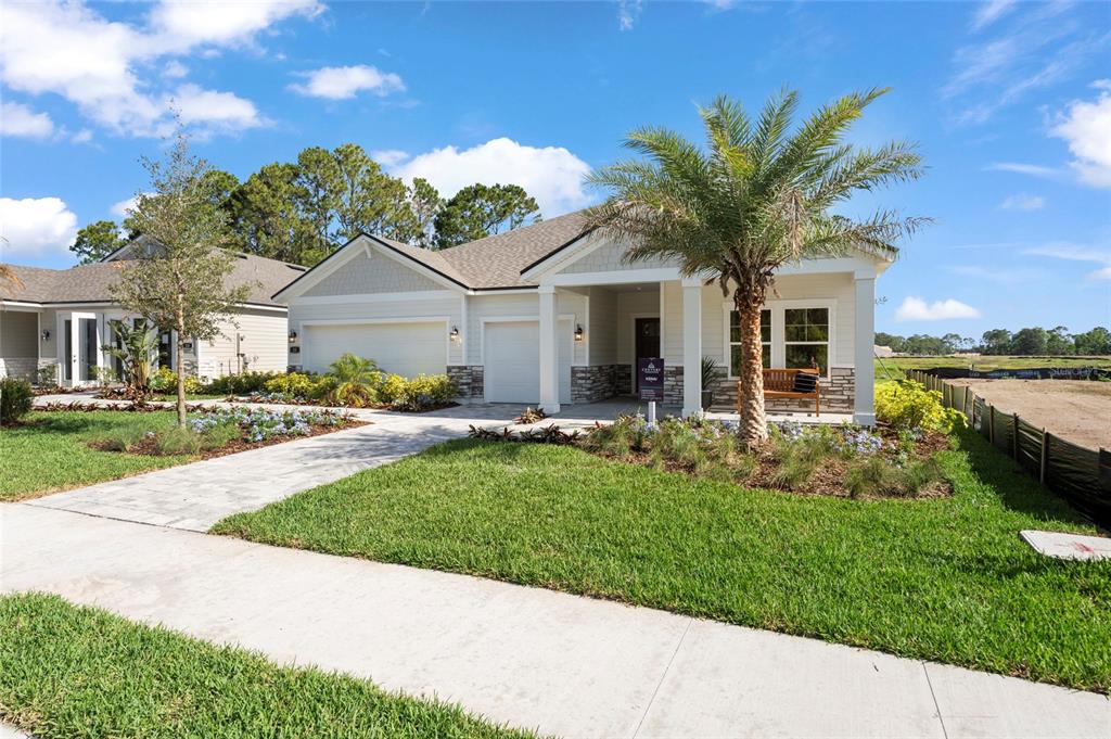 A single-story suburban house features a stone facade, a palm tree, and a paved driveway — 37 PEGASUS ROAD, FLAGLER BEACH, FL