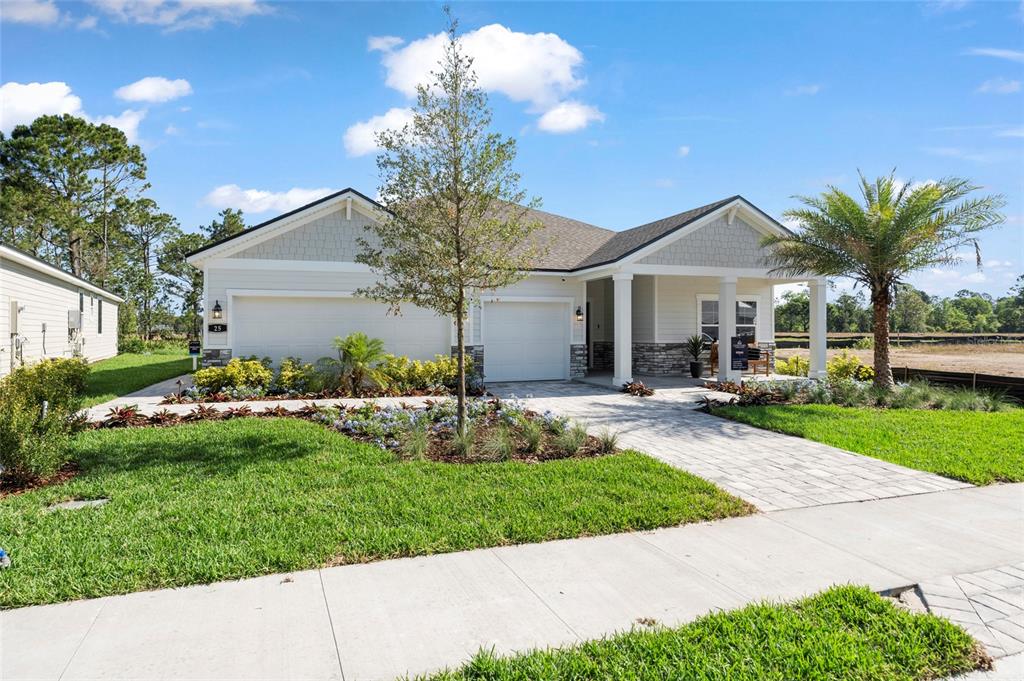 A single-story house with a two-car garage, stone accents, and a paved walkway — 37 PEGASUS ROAD, FLAGLER BEACH, FL