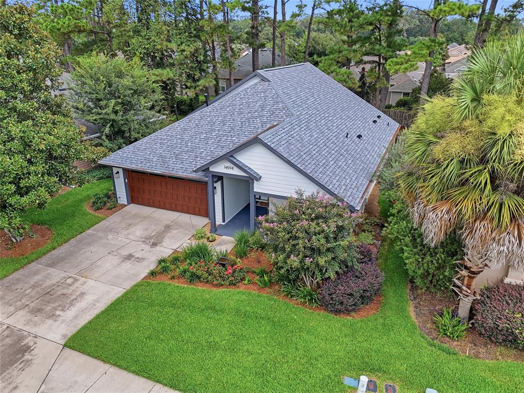 An aerial view of a single-story house with a gray roof, garage, and landscaped yard — 14594 NW 25TH AVENUE, NEWBERRY, FL