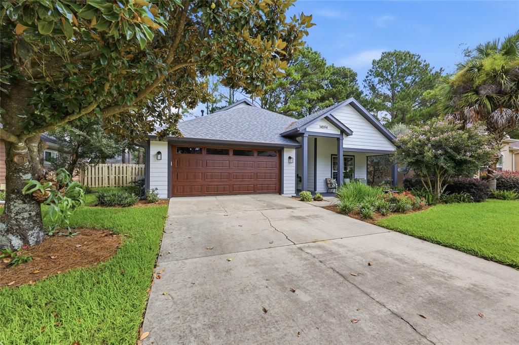 A single-story house with a white exterior, brown garage door, and a concrete driveway — 14594 NW 25TH AVENUE, NEWBERRY, FL