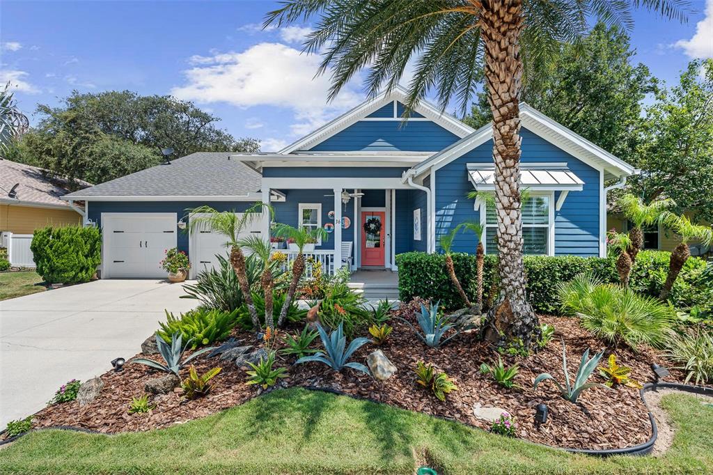 A blue single-story house with a white garage, a front porch, and landscaped front yard — 36 HIDDEN TREASURE DRIVE, PALM COAST, FL