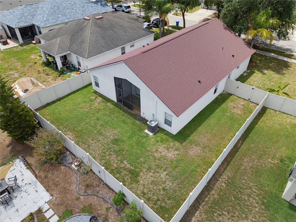 An aerial view shows a white house with a red roof and a fenced backyard — 7512 TURTLE VIEW DRIVE, RUSKIN, FL