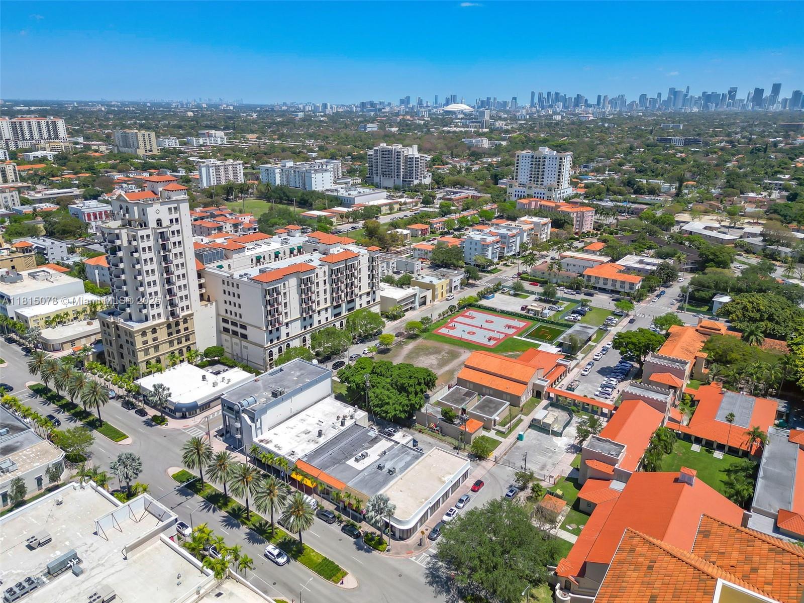 An aerial view shows a city neighborhood with apartment buildings, a basketball court, and streets — 1913 Ponce De Leon Blvd, Coral Gables FL 33134, CORAL GABLES, FL