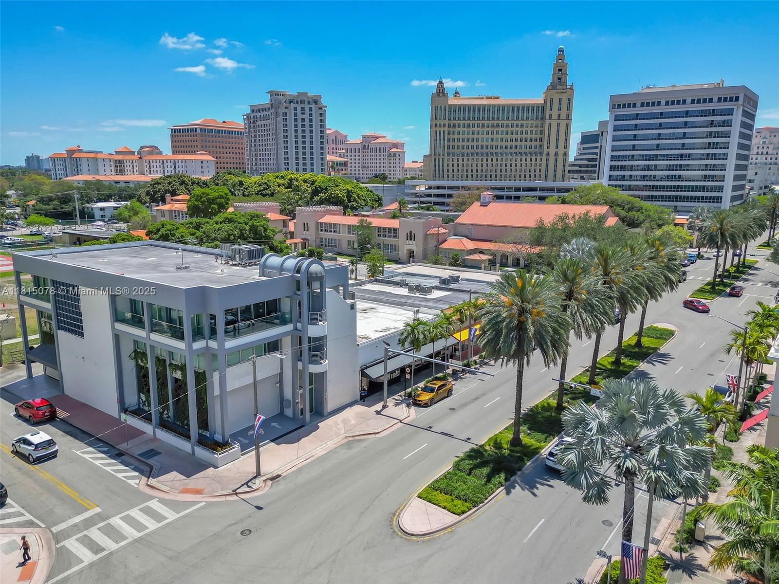An aerial view shows a modern commercial building with palm trees lining the adjacent street — 1913 Ponce De Leon Blvd, Coral Gables FL 33134, CORAL GABLES, FL