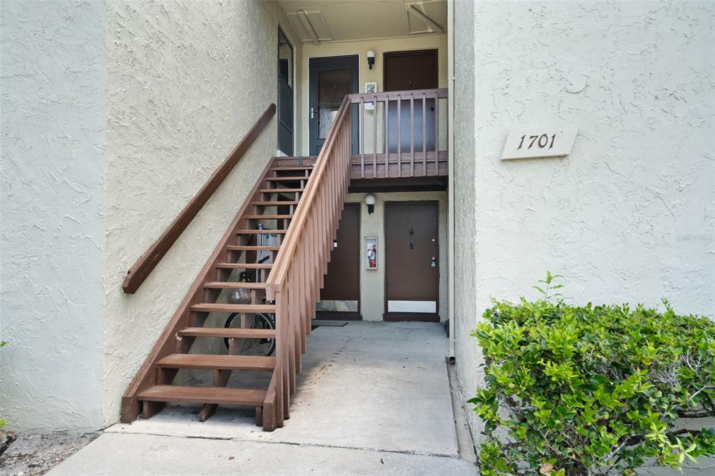 A kitchen with white cabinets, white appliances, light countertops, and light wood-look flooring — 4215 E BAY DRIVE UNIT 1701G, CLEARWATER, FL