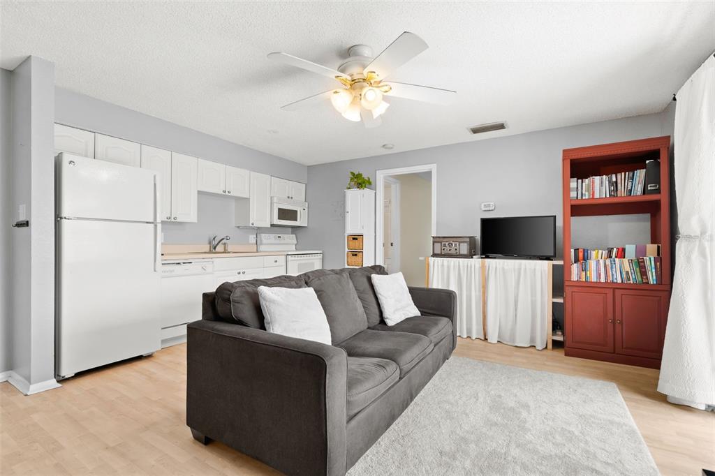 A bedroom with yellow walls, carpeted flooring, a bed, and a doorway leading to another room — 4215 E BAY DRIVE UNIT 1701G, CLEARWATER, FL