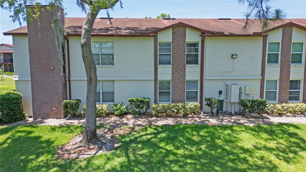 An aerial view shows multi-story apartment buildings, a swimming pool, and surrounding trees — 3455 COUNTRYSIDE BOULEVARD UNIT 11, CLEARWATER, FL