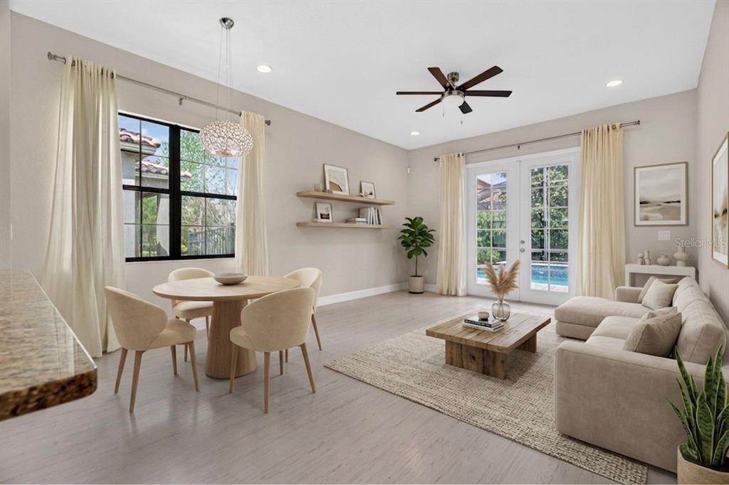 A bright, open-concept living and dining area with light wood floors, neutral furniture, and pool views — 10429 STAPELEY DR, ORLANDO, FL