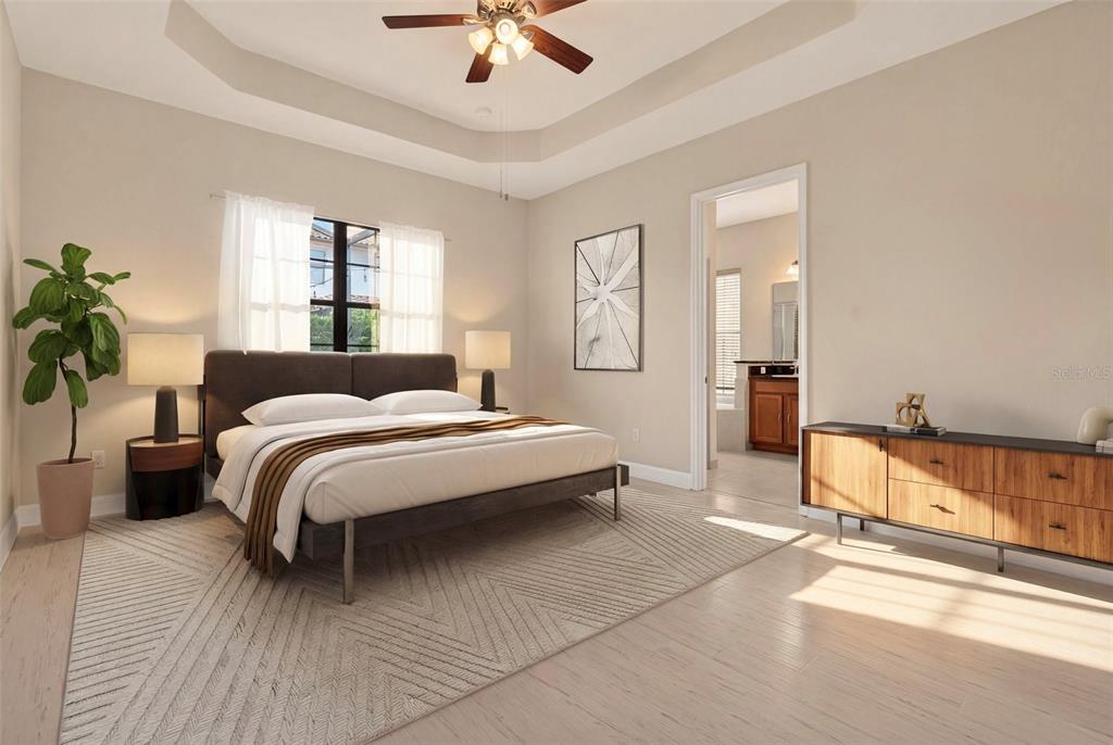 A bedroom features a tray ceiling, a bed with a dark frame, and a wooden dresser — 10429 STAPELEY DR, ORLANDO, FL