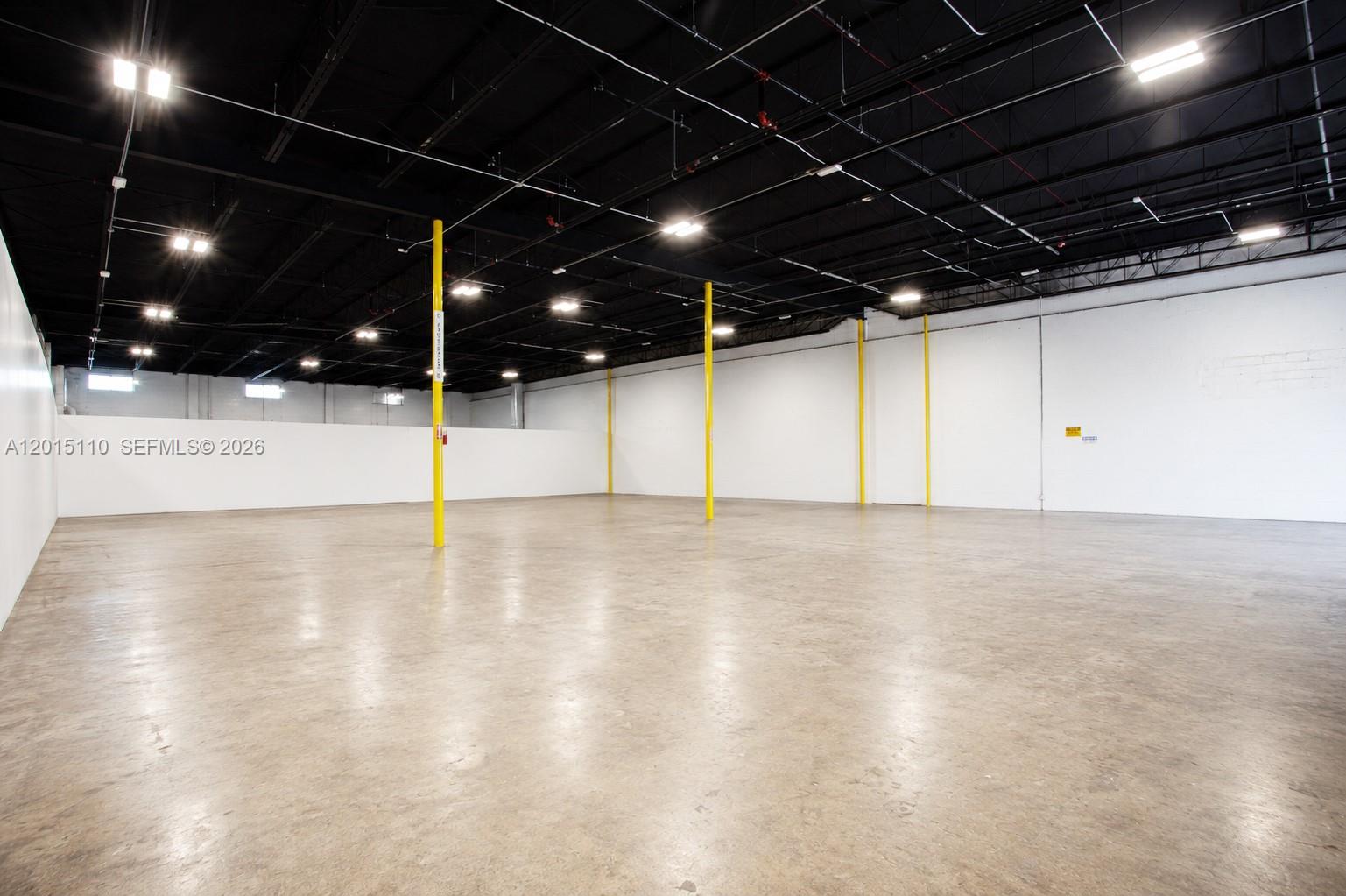A large, empty warehouse space features a concrete floor, white walls, and a black ceiling — 2290 W 8th Ave, Hialeah FL 33010, HIALEAH, FL