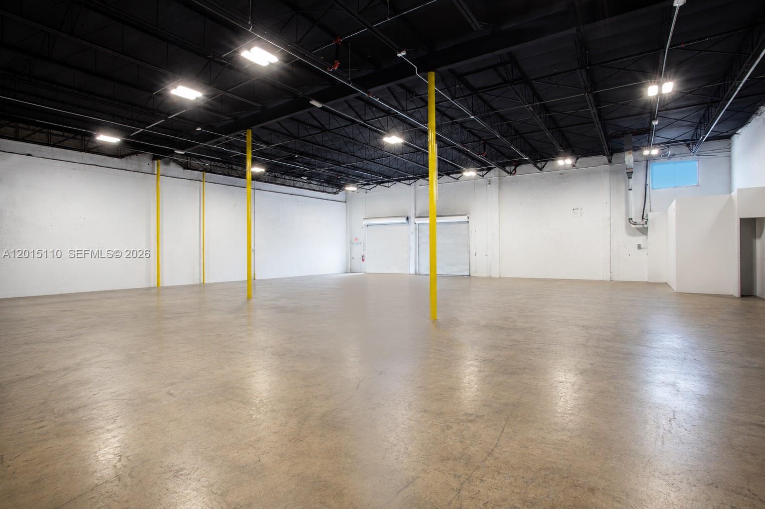 An empty industrial warehouse space features white walls, a black ceiling, and yellow support columns — 2290 W 8th Ave, Hialeah FL 33010, HIALEAH, FL