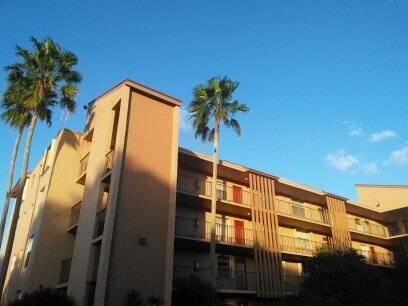 A multi-story apartment building with tan stucco walls and palm trees under a blue sky — 370 NW 76th Avenue # 104, Margate FL 33063, MARGATE, FL