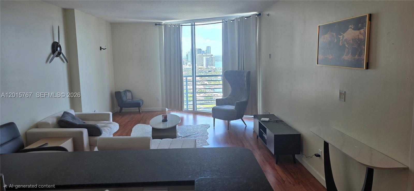 A living room features a high-backed chair, a sofa, and a balcony with city views — 325 S Biscayne Blvd # 4016, Miami FL 33131, MIAMI, FL