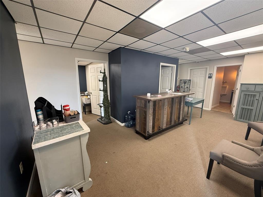 A waiting area features a reception desk, carpeted flooring, drop ceiling, and multiple doorways — 814 E SILVER SPRINGS BOULEVARD UNIT E, OCALA, FL