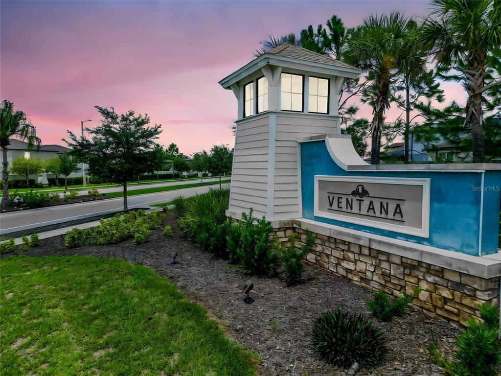 A stone and light-colored siding monument sign for Ventana stands beside a road at sunset — 11415 GREEN HARVEST DRIVE, RIVERVIEW, FL